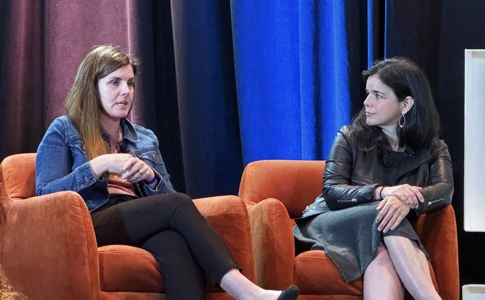 Christy Lillie speaking with a fellow panelist at a financial services leadership conference.